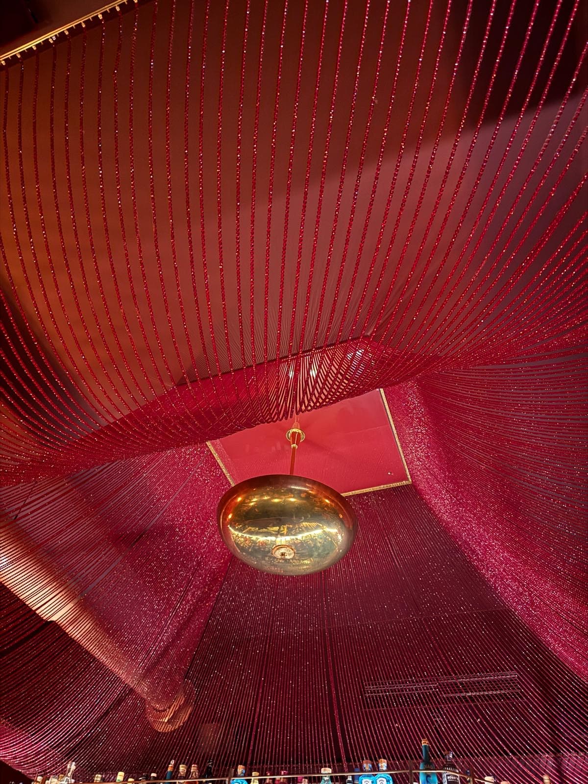 Social Carriage — red beaded ceiling and a gold chandelier